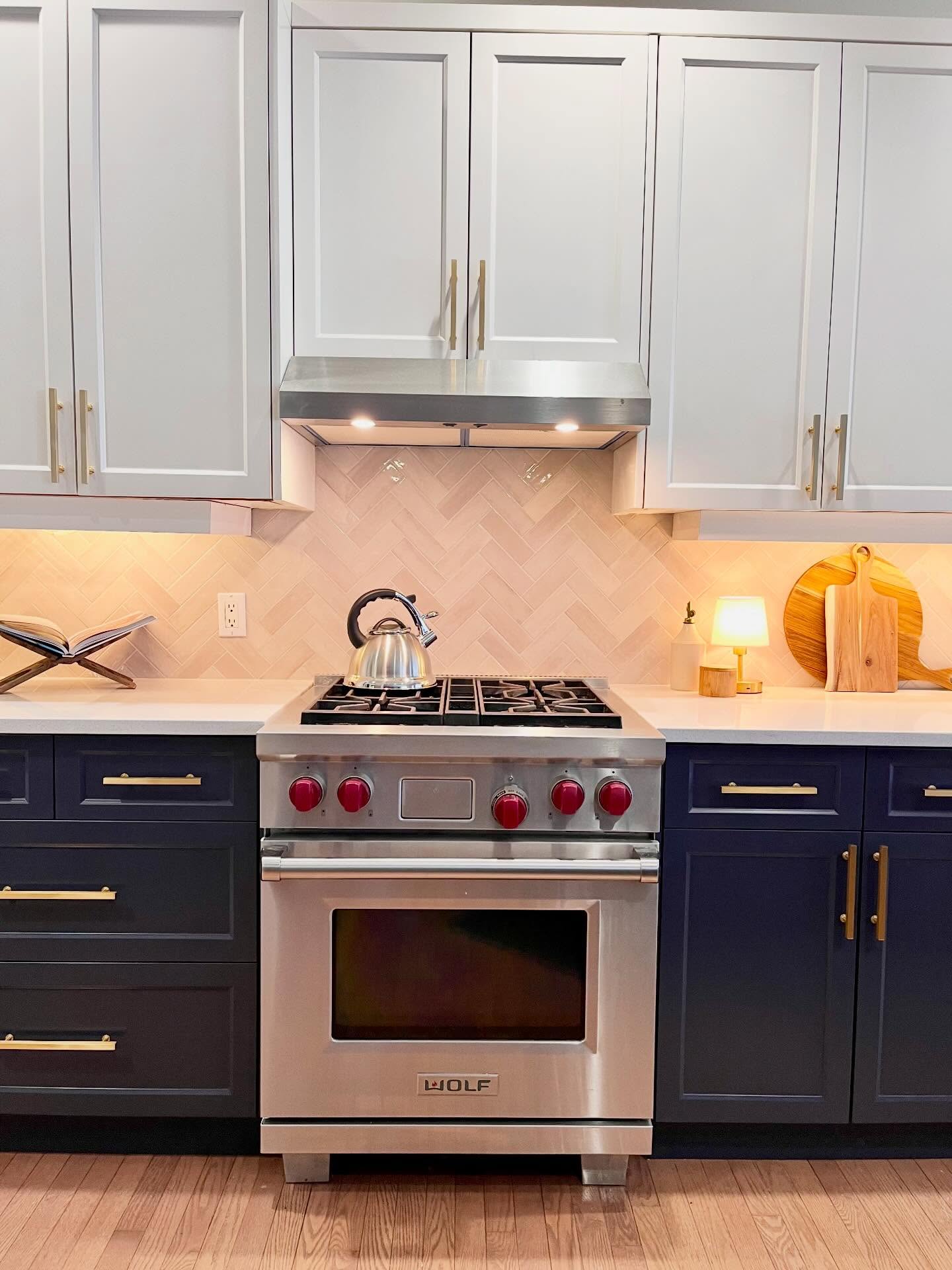 Head-on view of the Project Lily Wolf range with cream herringbone tile and two-tone shaker cabinets