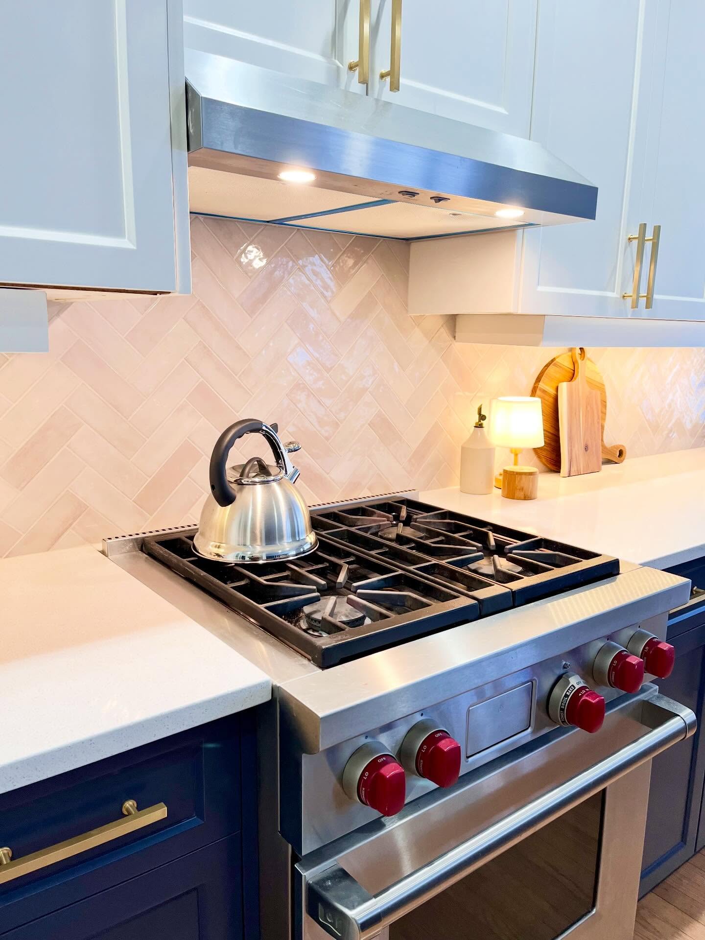 Closer finished view of Project Lily herringbone tile, navy drawers, and the Wolf range